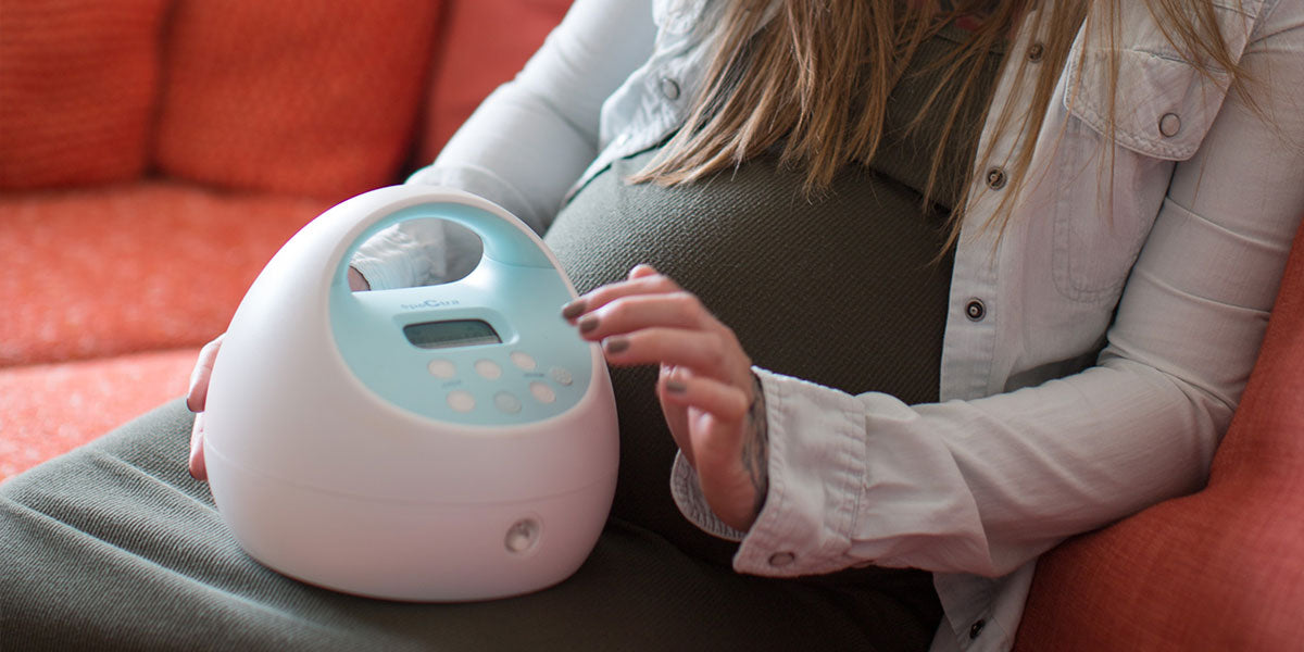 mom on couch with breast pump