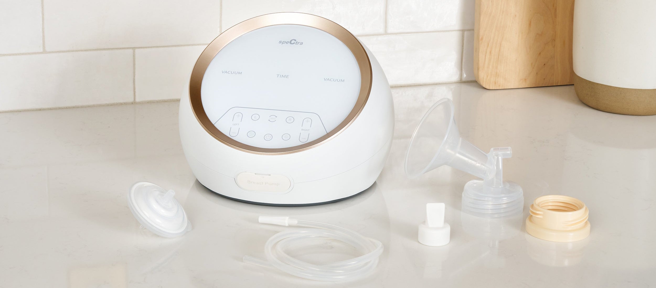 White breast pump with accessories on a kitchen counter
